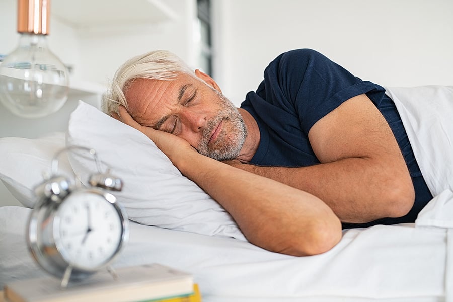 bigstock-Old-tired-man-sleeping-on-bed--363994525